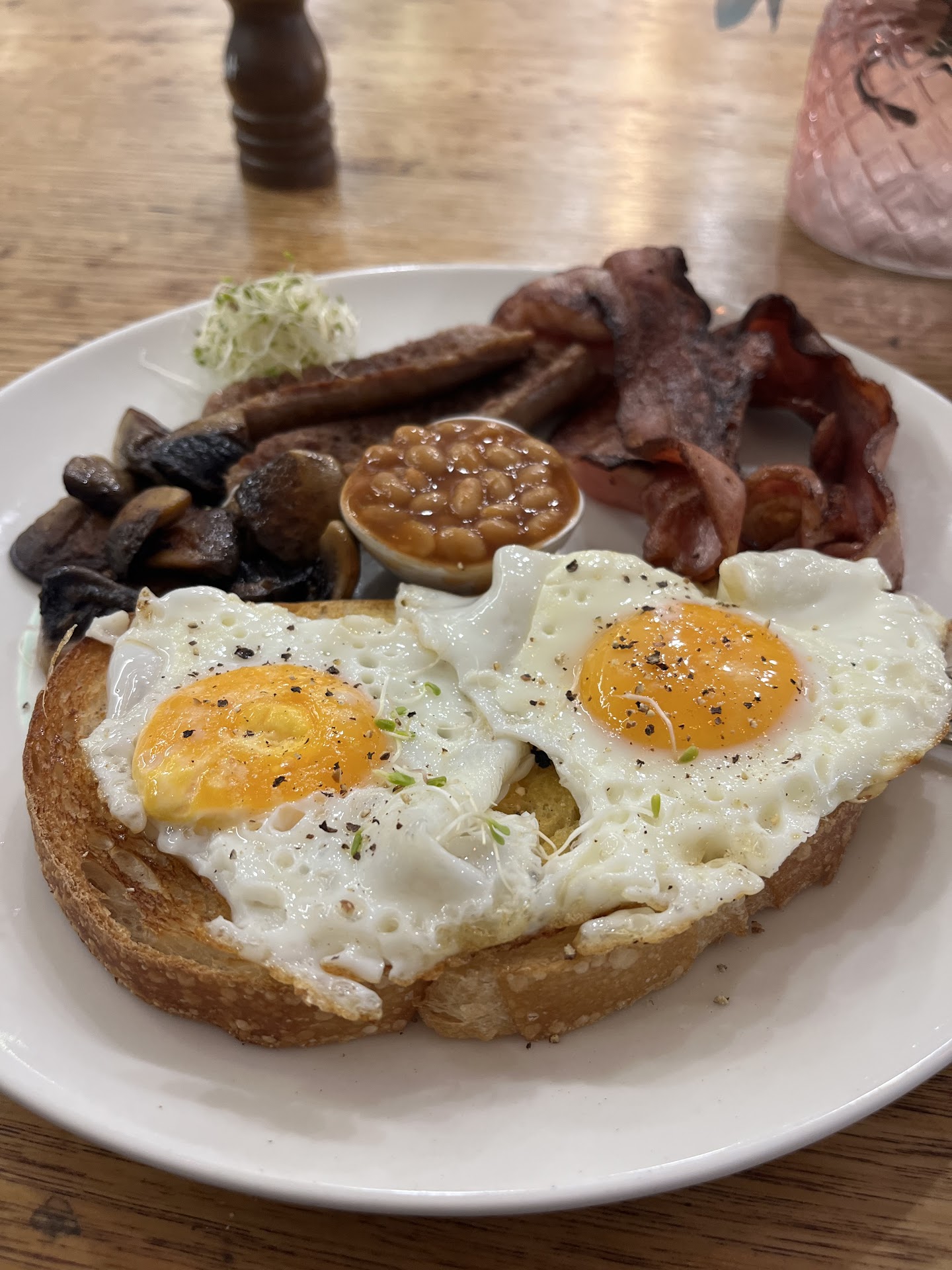 Big breakfast plate with eggs, bacon, sausage, mushrooms, and beans